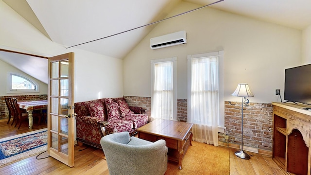 living area featuring wainscoting, a wall unit AC, wood finished floors, french doors, and high vaulted ceiling