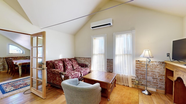 living room featuring a wainscoted wall, brick wall, hardwood / wood-style floors, a wall mounted air conditioner, and french doors