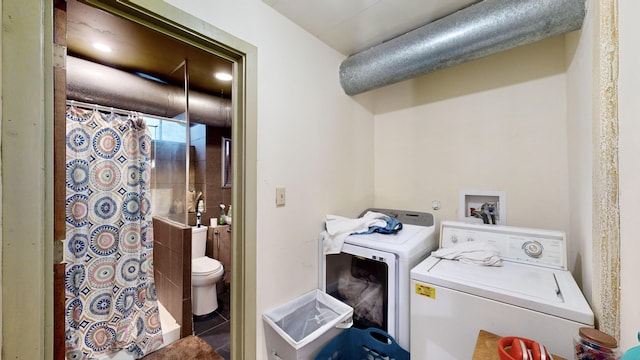 laundry room featuring tile patterned flooring, laundry area, and separate washer and dryer