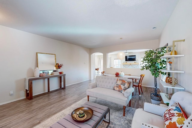 living room featuring wood-type flooring and an inviting chandelier