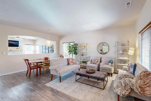 living room featuring hardwood / wood-style flooring and ceiling fan with notable chandelier