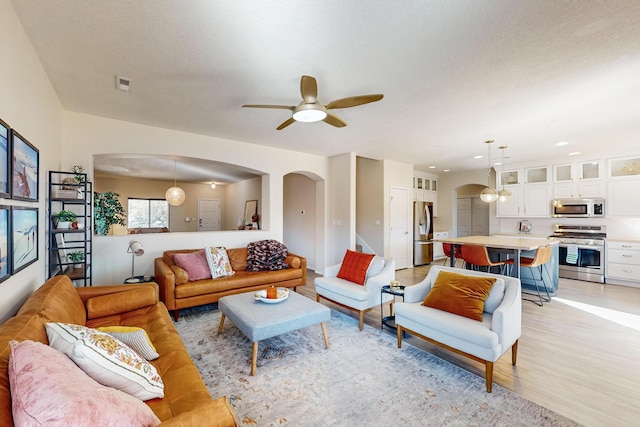 living room with ceiling fan and light hardwood / wood-style flooring