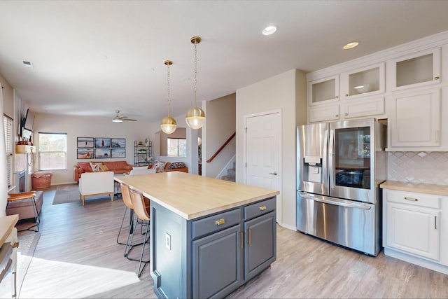 kitchen featuring white cabinets, hanging light fixtures, a kitchen island, gray cabinets, and stainless steel refrigerator with ice dispenser