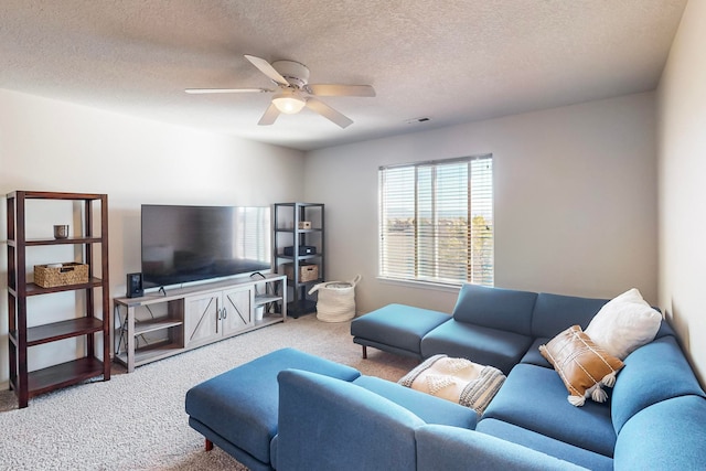 carpeted living room with a textured ceiling and ceiling fan