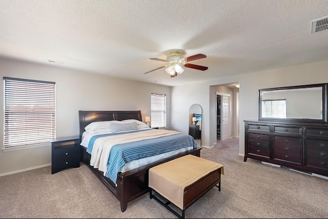 carpeted bedroom featuring a textured ceiling and ceiling fan