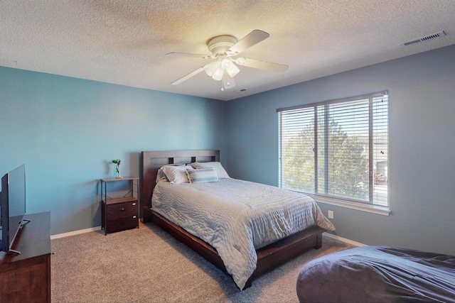 bedroom featuring a textured ceiling, carpet flooring, and ceiling fan