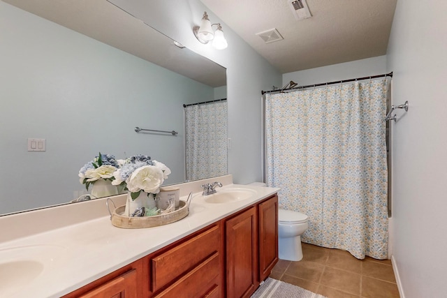 bathroom featuring a textured ceiling, toilet, vanity, a shower with shower curtain, and tile patterned flooring