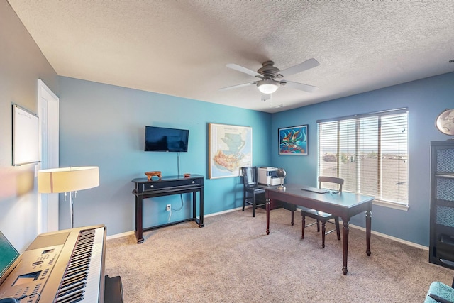 office space featuring a textured ceiling, light colored carpet, and ceiling fan