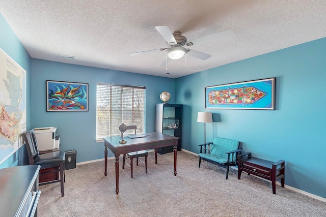 office featuring a textured ceiling, light colored carpet, and ceiling fan