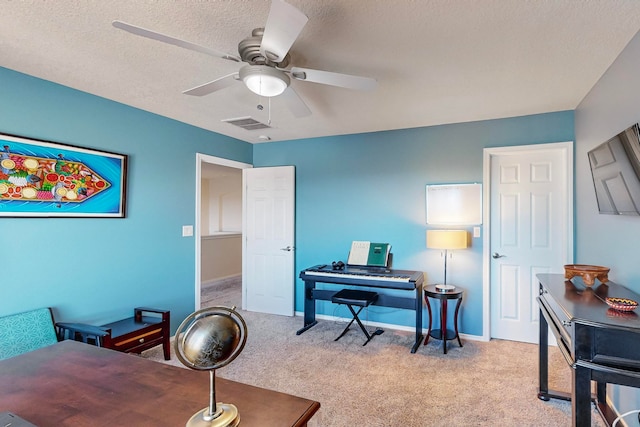 office space with light carpet, a textured ceiling, and ceiling fan