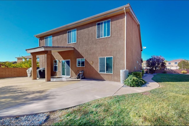 back of property with a patio and a lawn