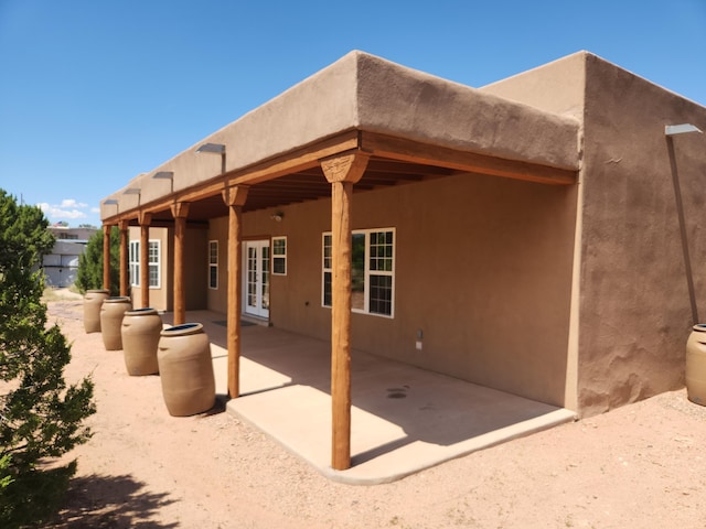 back of property featuring french doors and a patio area