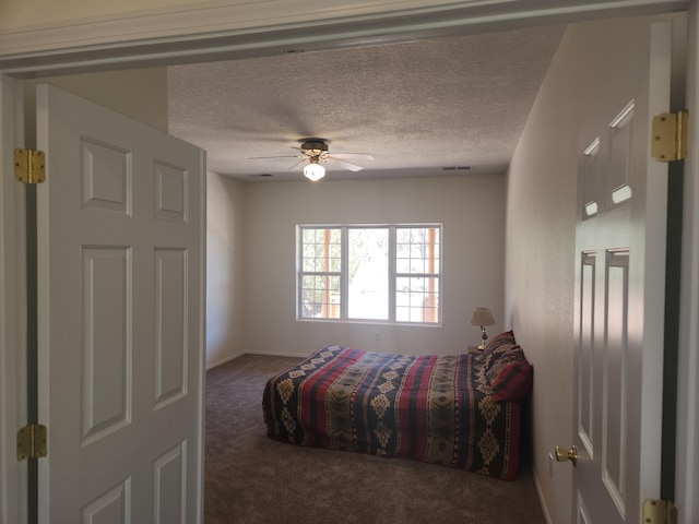 carpeted bedroom featuring ceiling fan and a textured ceiling