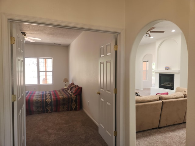 bedroom featuring a large fireplace, carpet flooring, and a textured ceiling