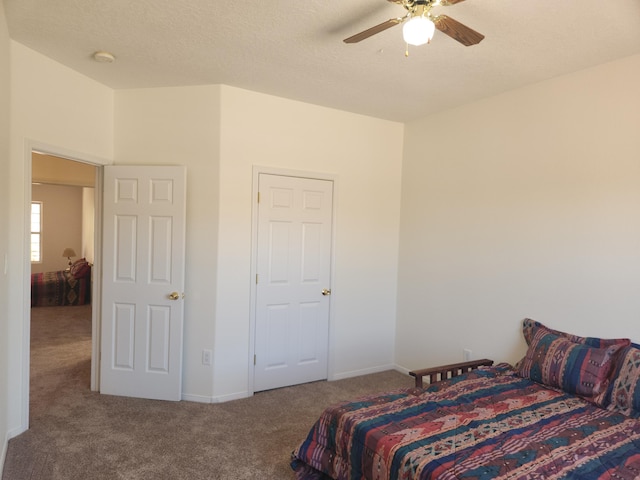 carpeted bedroom with ceiling fan and a textured ceiling