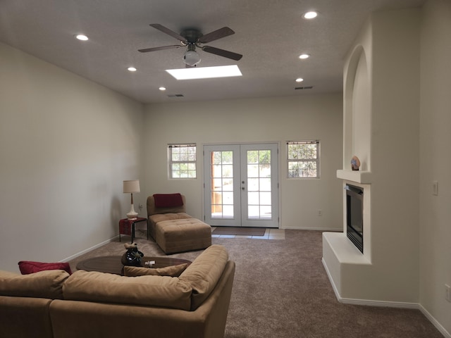 carpeted living room with ceiling fan and french doors