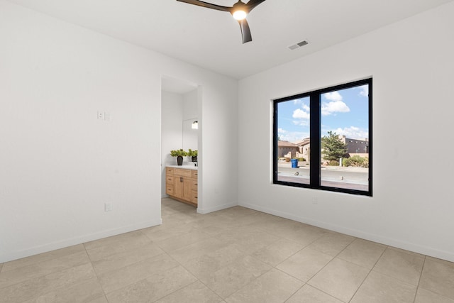 tiled spare room featuring ceiling fan