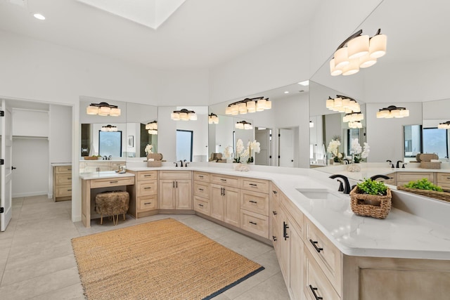 bathroom featuring tile patterned flooring, vanity, and a high ceiling