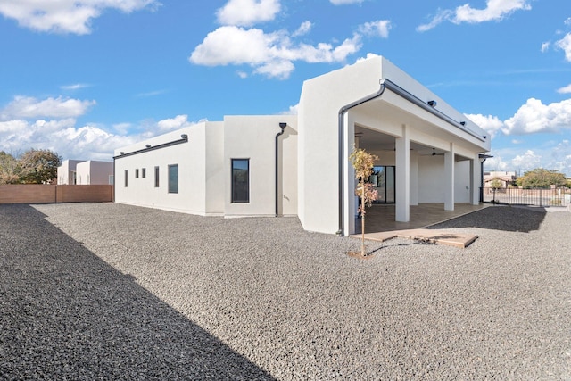 rear view of house with ceiling fan and a patio area