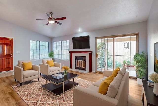 living room with light wood-type flooring, plenty of natural light, and vaulted ceiling