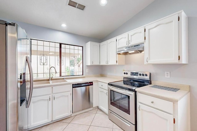 kitchen featuring stainless steel appliances, white cabinetry, sink, light tile patterned floors, and lofted ceiling