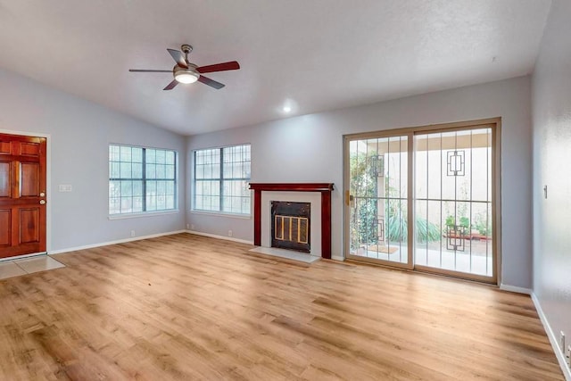 unfurnished living room with light hardwood / wood-style floors, plenty of natural light, and lofted ceiling