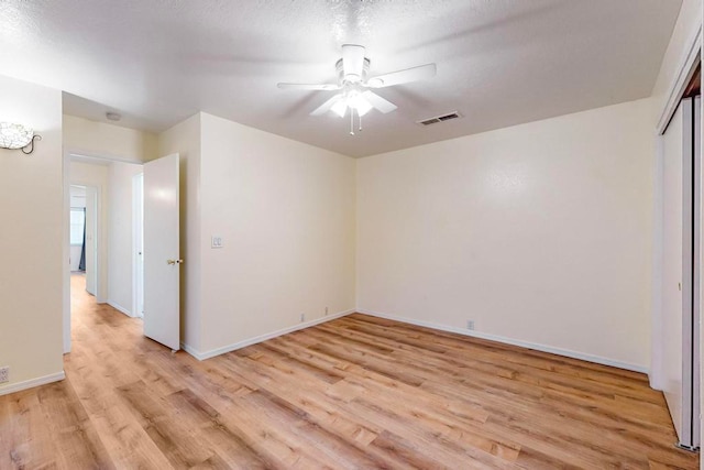 empty room featuring a textured ceiling, ceiling fan, and light hardwood / wood-style flooring