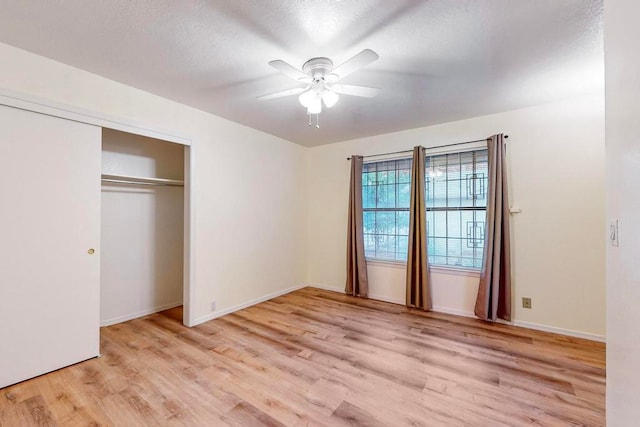 unfurnished bedroom featuring light hardwood / wood-style floors, ceiling fan, a textured ceiling, and a closet