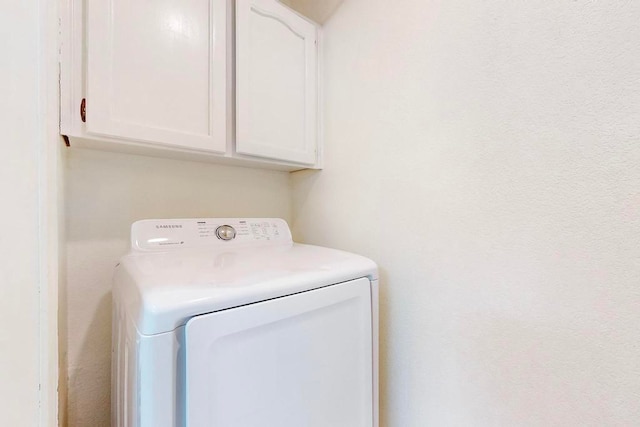 washroom featuring washer / clothes dryer and cabinets