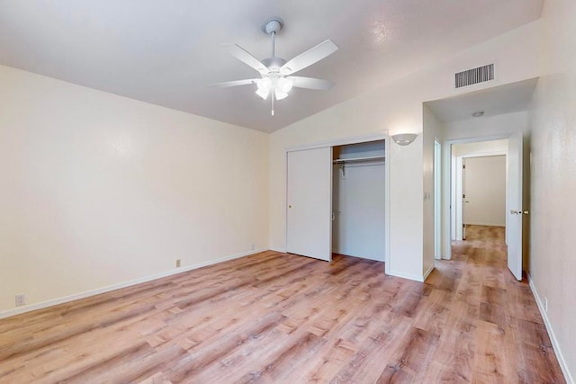 unfurnished bedroom featuring light hardwood / wood-style floors, ceiling fan, a closet, and lofted ceiling