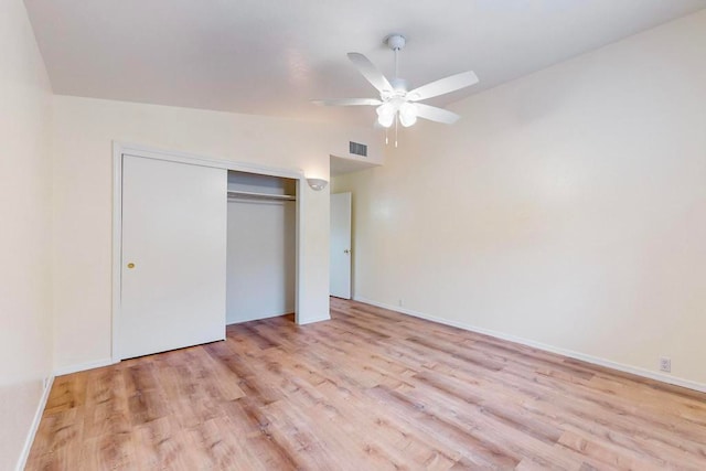 unfurnished bedroom with a closet, vaulted ceiling, ceiling fan, and light hardwood / wood-style flooring