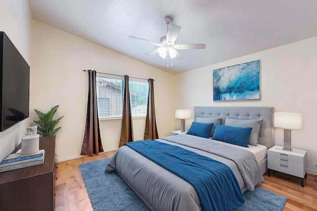 bedroom with light wood-type flooring, lofted ceiling, and ceiling fan