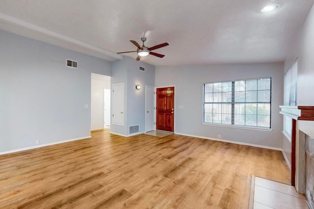 unfurnished living room featuring light wood-type flooring, vaulted ceiling, and ceiling fan