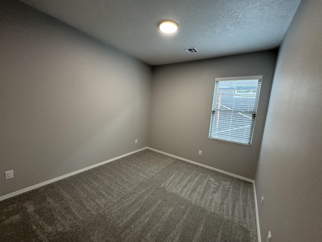 carpeted empty room with a textured ceiling