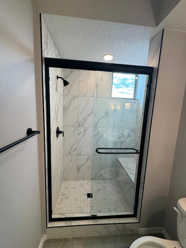 bathroom with tile patterned floors, a shower with door, and toilet