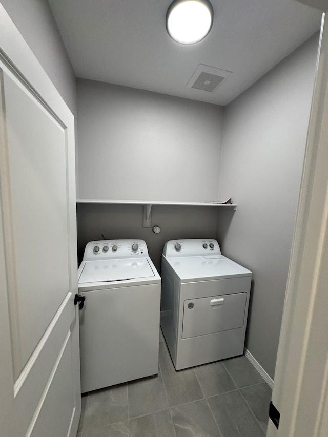 laundry area featuring tile patterned flooring and washing machine and dryer