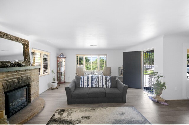 living room featuring light hardwood / wood-style flooring and a brick fireplace