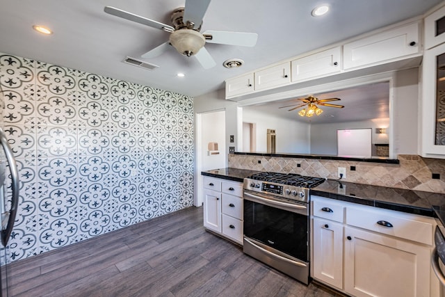 kitchen with stainless steel gas stove, white cabinets, and dark wood-type flooring