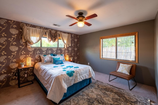 carpeted bedroom with multiple windows and ceiling fan