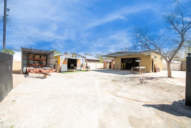 rear view of property with an outbuilding and a carport