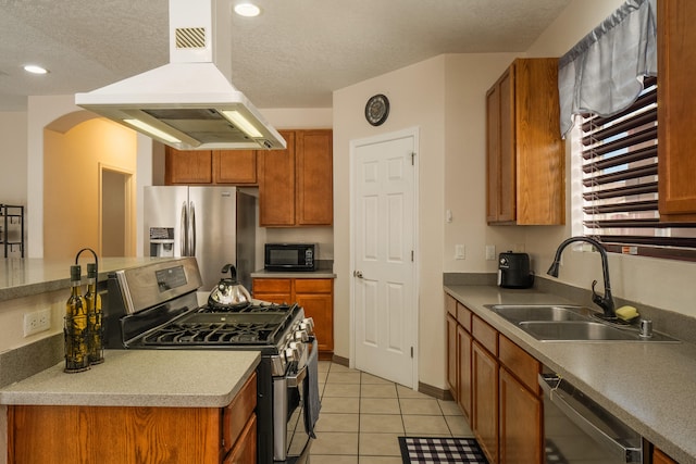 kitchen featuring sink, island range hood, a textured ceiling, stainless steel appliances, and light tile patterned floors