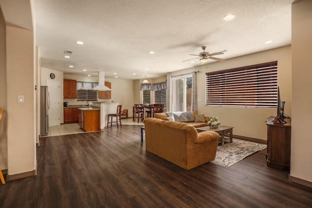 living room with sink, ceiling fan, a textured ceiling, and dark hardwood / wood-style flooring