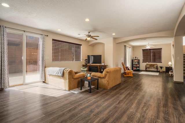 living room featuring dark hardwood / wood-style floors, a textured ceiling, and ceiling fan