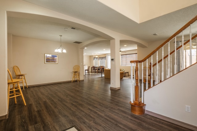 foyer entrance with dark wood-type flooring and an inviting chandelier