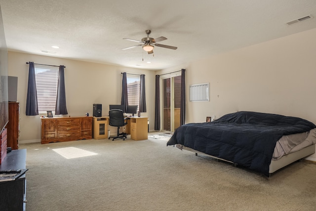 carpeted bedroom featuring ceiling fan, a textured ceiling, and multiple windows