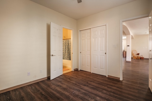 unfurnished bedroom featuring a closet, ceiling fan, and dark hardwood / wood-style flooring