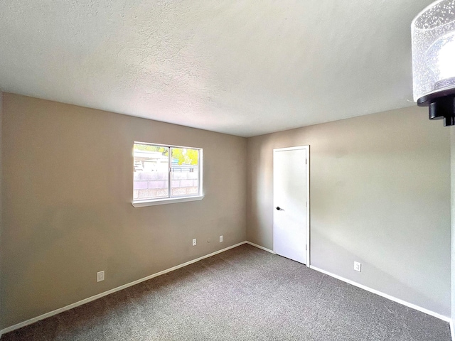 carpeted spare room featuring a textured ceiling