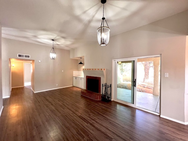 unfurnished living room with a chandelier, a fireplace, and dark hardwood / wood-style flooring