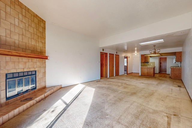 unfurnished living room featuring light carpet and a tile fireplace