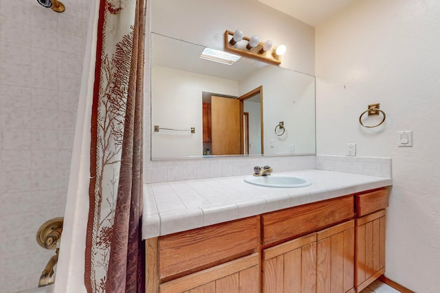 bathroom featuring walk in shower and vanity